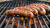 Bratwurst Kerntemperatur: Bratwürste mit Grillstreifen auf dem Rost über glühender Holzkohle